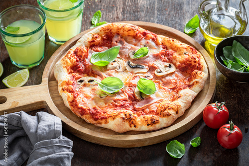 Traditional Capricciosa pizza on wooden table. Classic Italian cuisine.