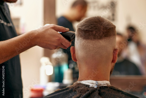 Barber shaving caucasian man in barber shop © producer