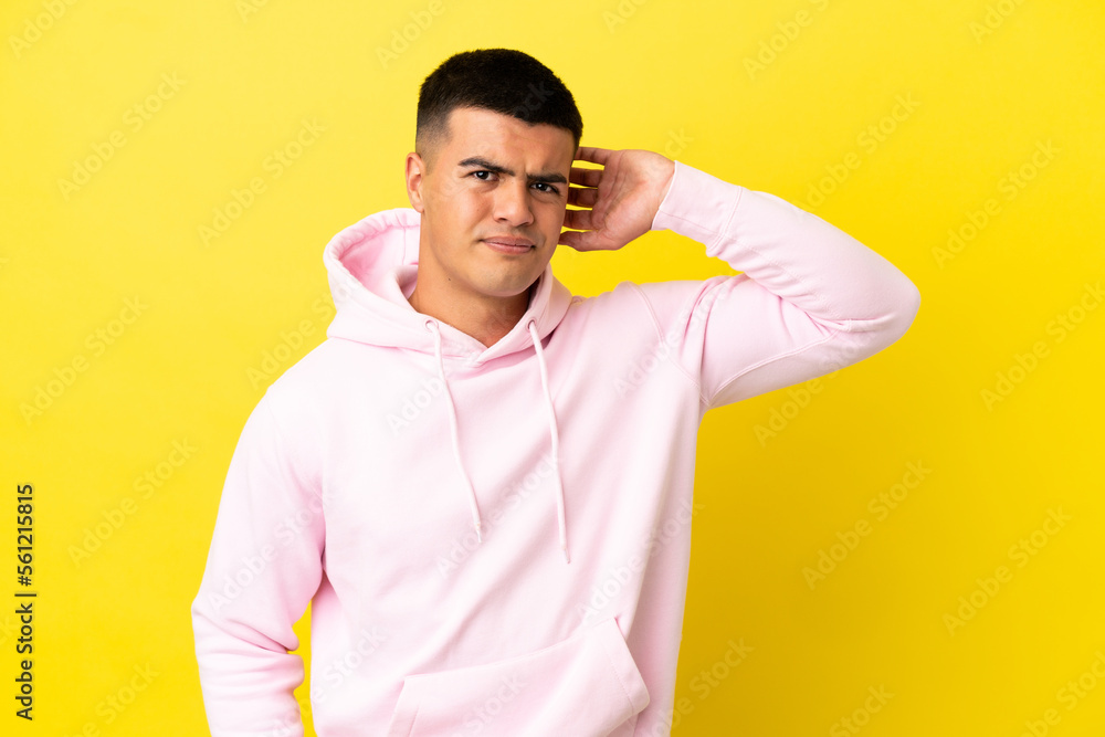Young handsome man over isolated yellow background having doubts Young handsome man over isolated yellow background having doubts