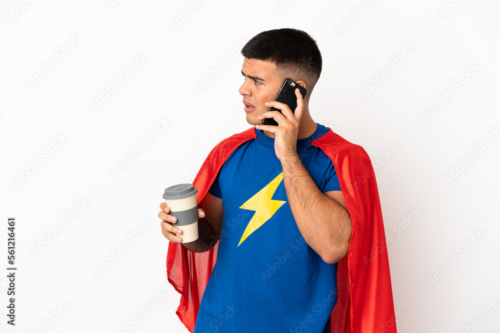 Super Hero over isolated white background holding coffee to take away and a mobile Super Hero over isolated white background holding coffee to take away and a mobile