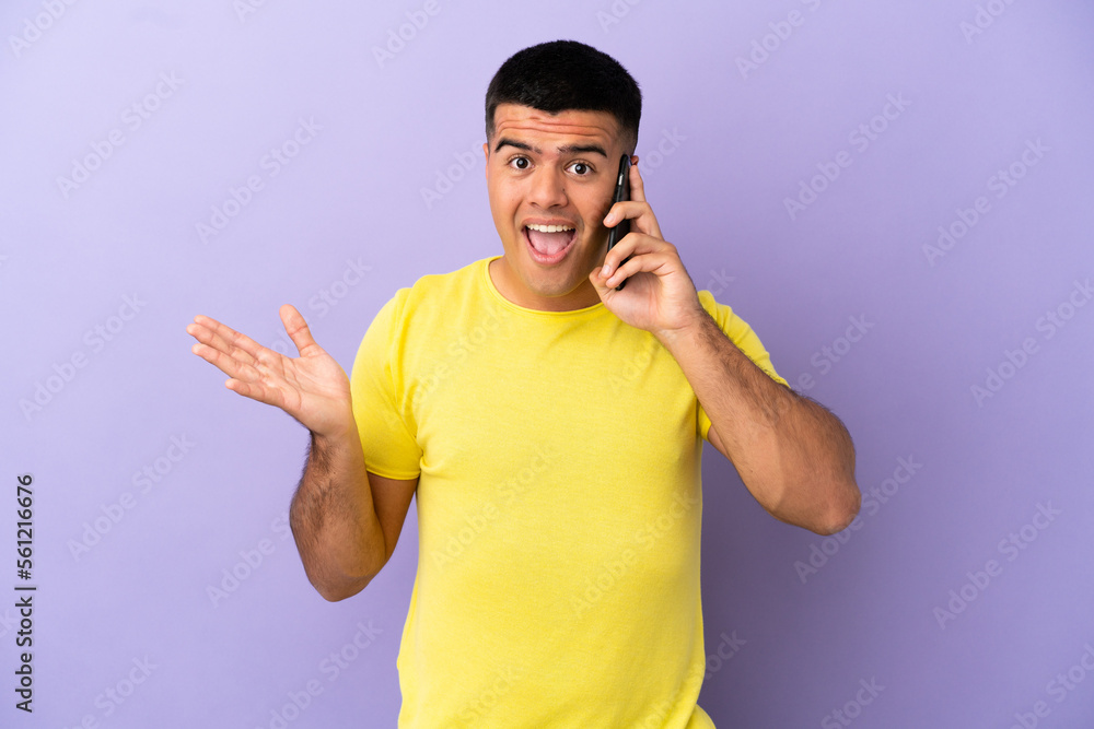 Young handsome man using mobile phone over isolated purple background with shocked facial expression Young handsome man using mobile phone over isolated purple background with shocked facial expression