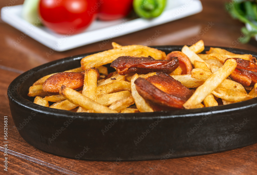 Frying pan with pieces fried sausage and potato Frying pan with pieces fried sausage and potato