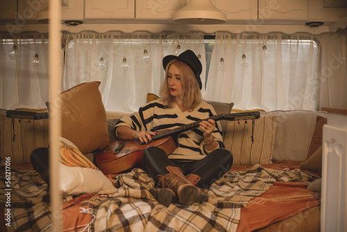 Hippie Boho girl with guitar in trailer, rest relaxing vibe © T.Den_Team