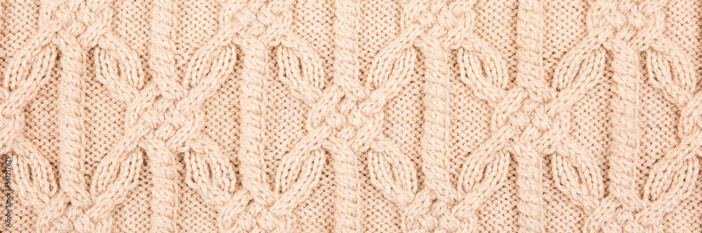 Knitted beige background. Large knitted fabric with a pattern. Close-up of a knitted blanket. Horizontal ornament. Banner Knitted beige background. Large knitted fabric with a pattern. Close-up of a knitted blanket. Horizontal ornament. Banner