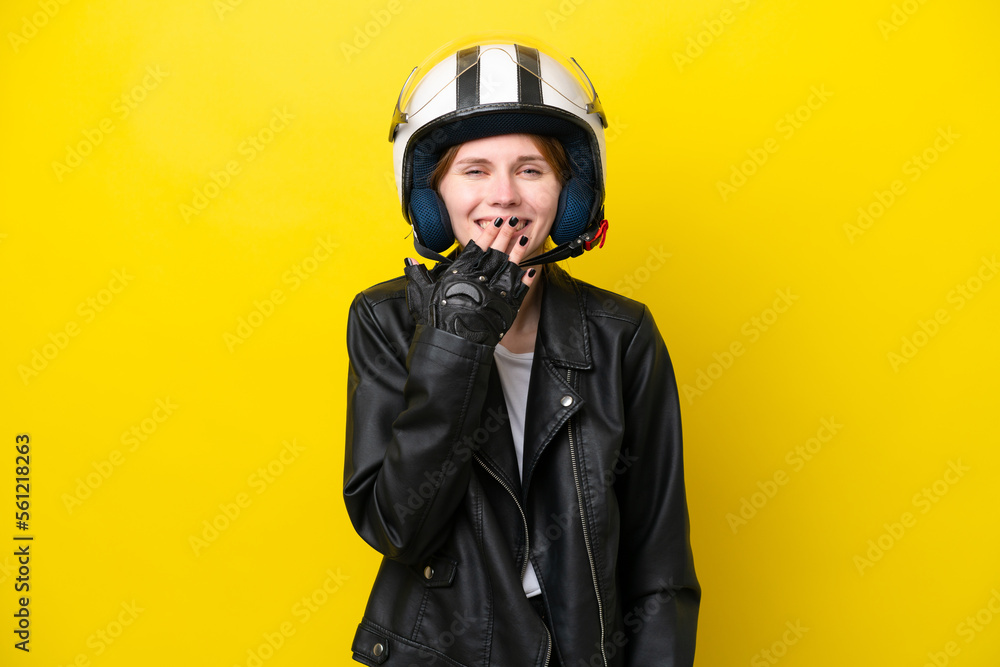 Young English woman with a motorcycle helmet isolated on yellow background happy and smiling covering mouth with hand Young English woman with a motorcycle helmet isolated on yellow background happy and smiling covering mouth with hand