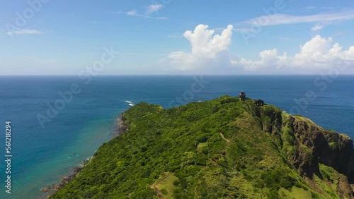 Lighthouse on a hill and blue ocean. Cape Engano. Palaui Island. Santa Ana Philippines. photo