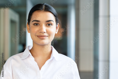 Happy and friendly south asian, Indian woman office worker looking and smiling at you