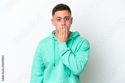 Young brazilian man isolated on white background covering mouth with hand © luismolinero