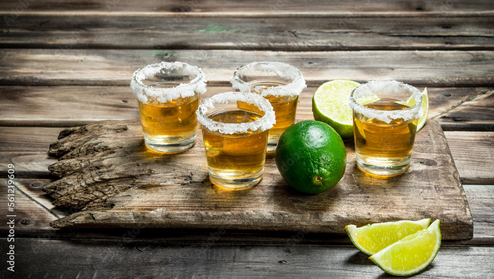 Tequila in a shot glass on a cutting Board with lime. Tequila in a shot glass on a cutting Board with lime.