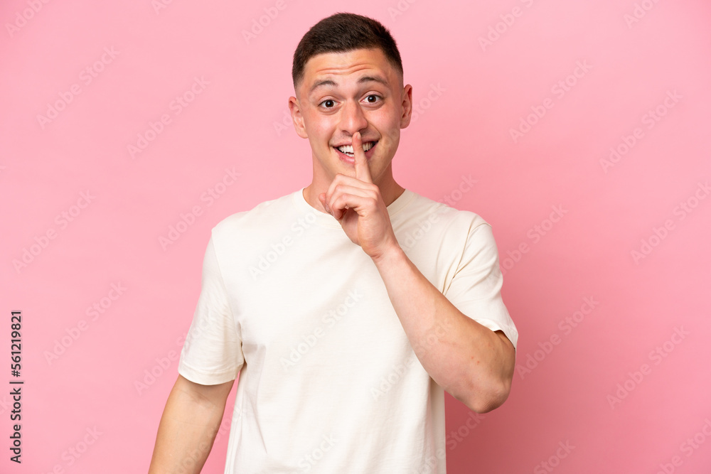 Young Brazilian man isolated on pink background showing a sign of silence gesture putting finger in mouth Young Brazilian man isolated on pink background showing a sign of silence gesture putting finger in mouth