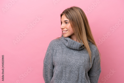 Young caucasian woman isolated on pink bakcground looking to the side and smiling © luismolinero