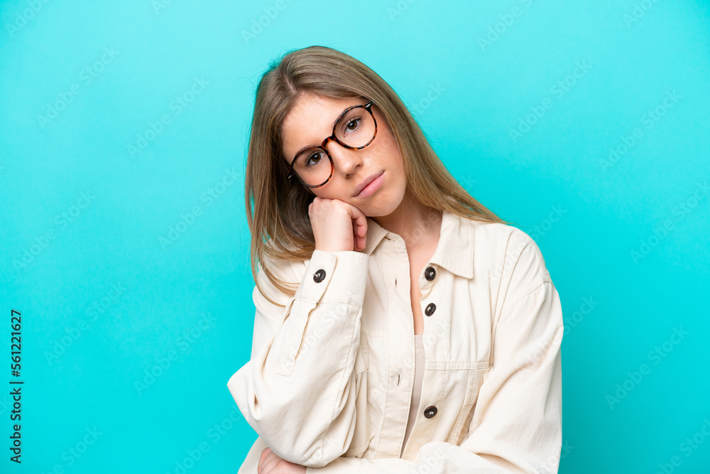 Young caucasian woman isolated on blue background With glasses and with sad expression Young caucasian woman isolated on blue background With glasses and with sad expression