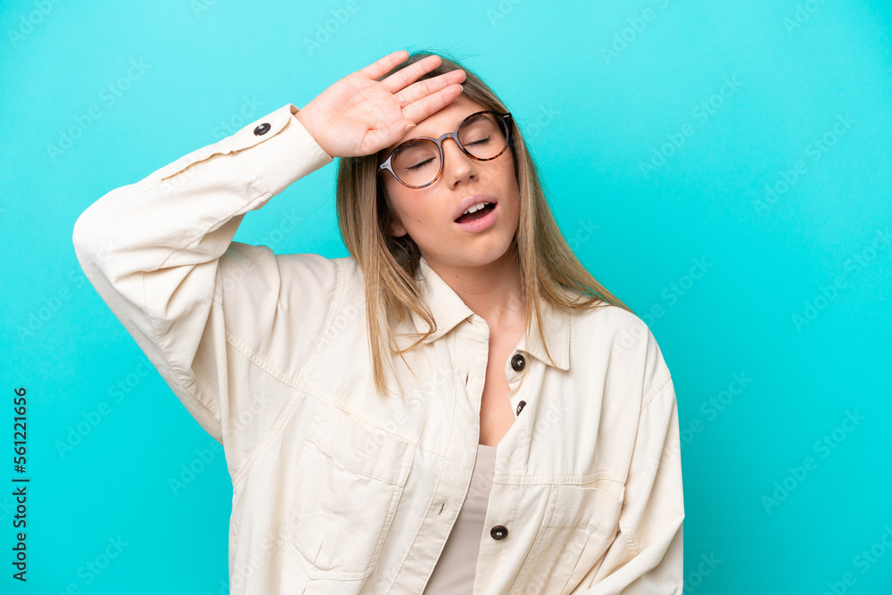 Young caucasian woman isolated on blue background With glasses and tired Young caucasian woman isolated on blue background With glasses and tired