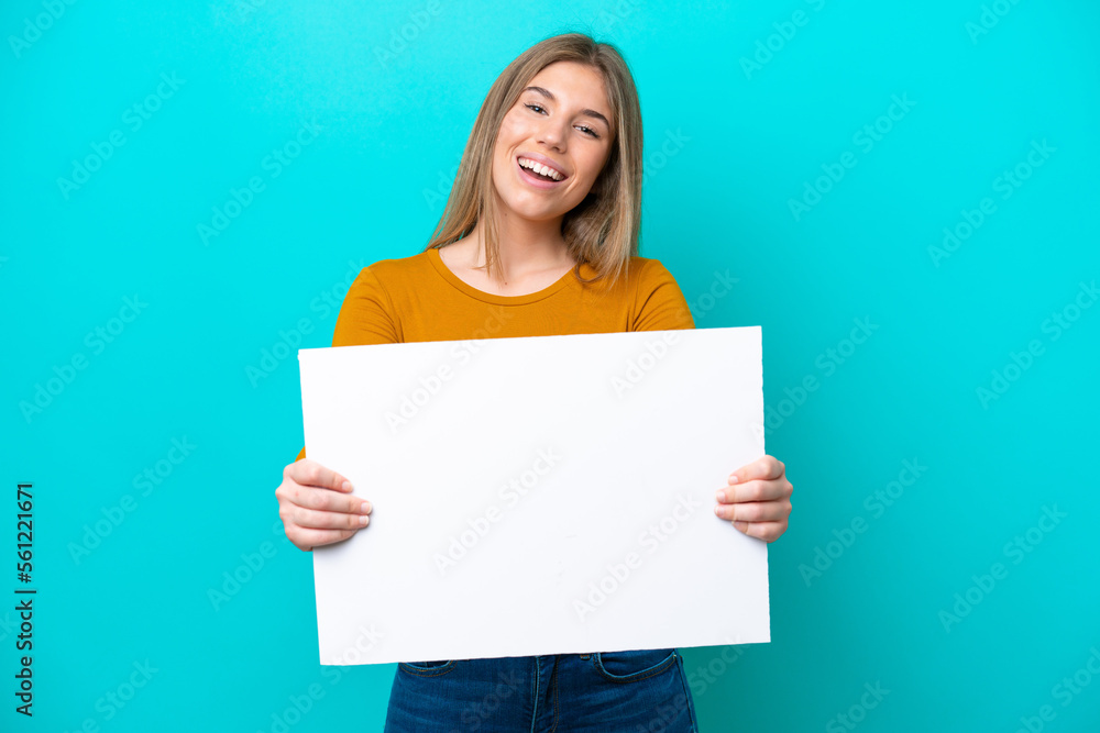 Young caucasian woman isolated on blue background holding an empty placard with happy expression Young caucasian woman isolated on blue background holding an empty placard with happy expression