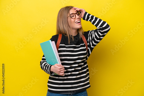 Young student woman isolated on yellow background background smiling a lot