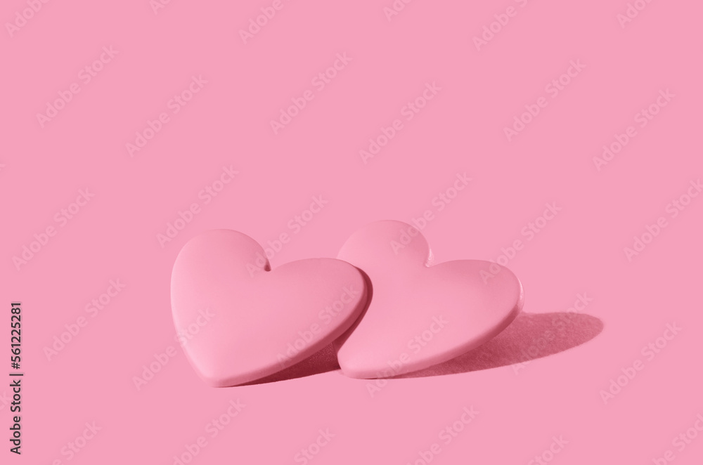 two pink hearts on pink background. Minimal monochrome for St Valentines day or 14 February. Mothers Day or wedding invitation