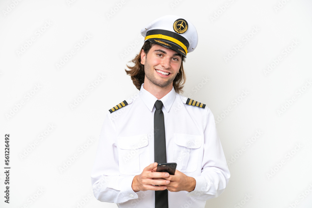 handsome Airplane pilot isolated on white background sending a message with the mobile handsome Airplane pilot isolated on white background sending a message with the mobile