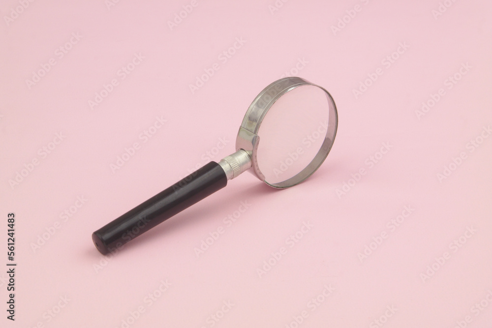 Magnifying glass on pink background.
