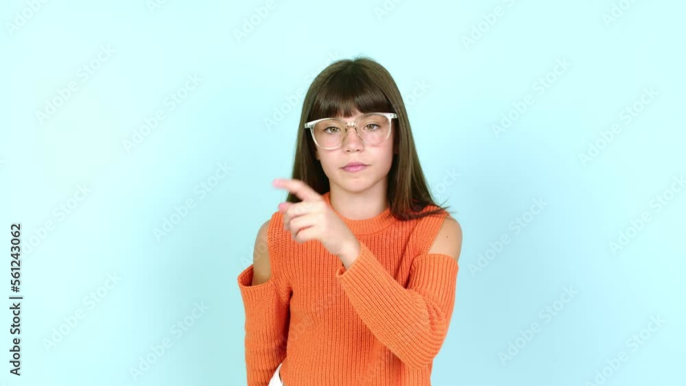 Little girl with glasses and doing silence gesture Little girl with glasses and doing silence gesture