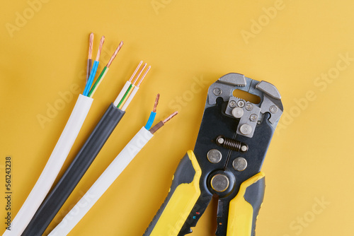 Cable stripping and crimping tool, Wire strippers isolated on yellow background photo