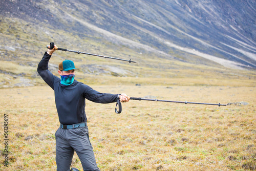 Hiker adds humor to a backpacking trip, using poles as swords photo