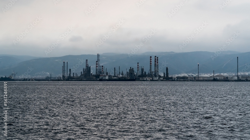 Oil refinery plant. Petrochemical factory and merchant ships in Gulf of Kocaeli Izmit Turkey. Factory causing environmental disaster with chemical gas. Noise and grain included. Selective focus