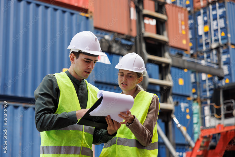 Foreman and woman engineer are looking in checking list for control and loading containers box from factory to cargo freight ship. Concept : Shipping import export industry Logistics business. Foreman and woman engineer are looking in checking list for control and loading containers box from factory to cargo freight ship. Concept : Shipping import export industry Logistics business.