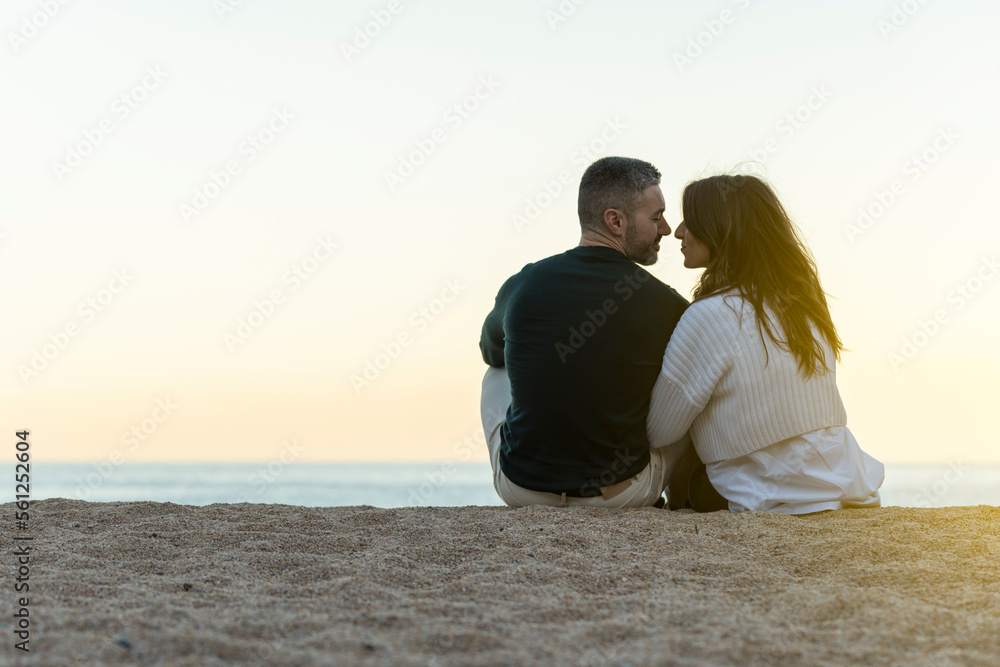 Couple in love very close together on the sand of the beach