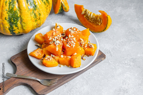 Traditional Turkish Pumpkin Dessert with sherbet on rustic table and fresh sliced pumpkins