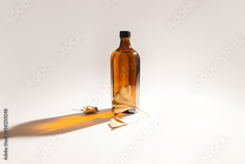 Obraz na plátně Ginkgo biloba essential extract in a bottle and golden leaves