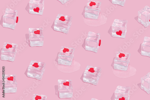 Seamless pattern of ice cubes with red hearts on pink background. Surreal love or fashion idea in a minimalist style.