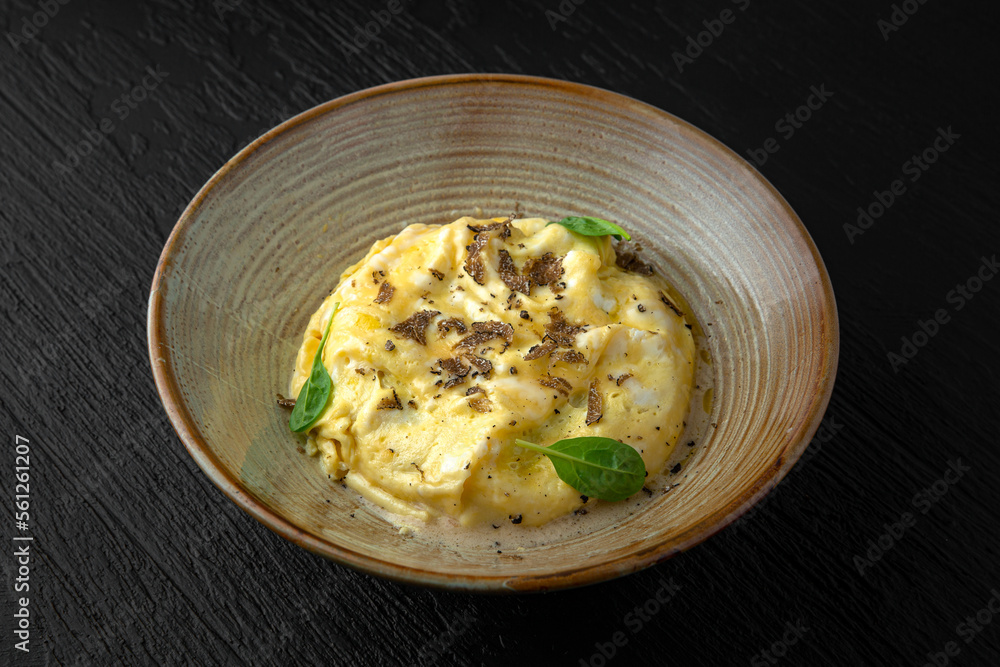 Polenta with mushroom julienne and truffle in a ceramic plate on a dark textured background. Restaurant menu Isolated on black Polenta with mushroom julienne and truffle in a ceramic plate on a dark textured background. Restaurant menu Isolated on black