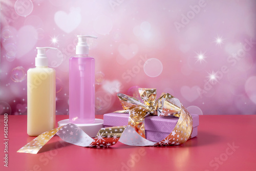 bottles for cosmetics and a gift box on an abstract background with hearts