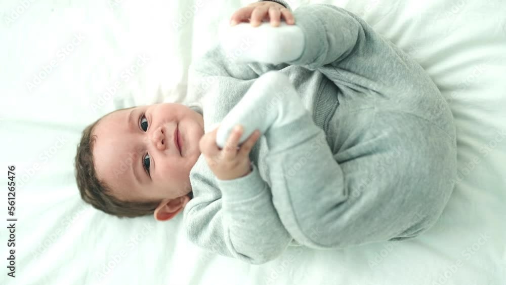 Adorable hispanic baby lying on bed crying at bedroom Adorable hispanic baby lying on bed crying at bedroom