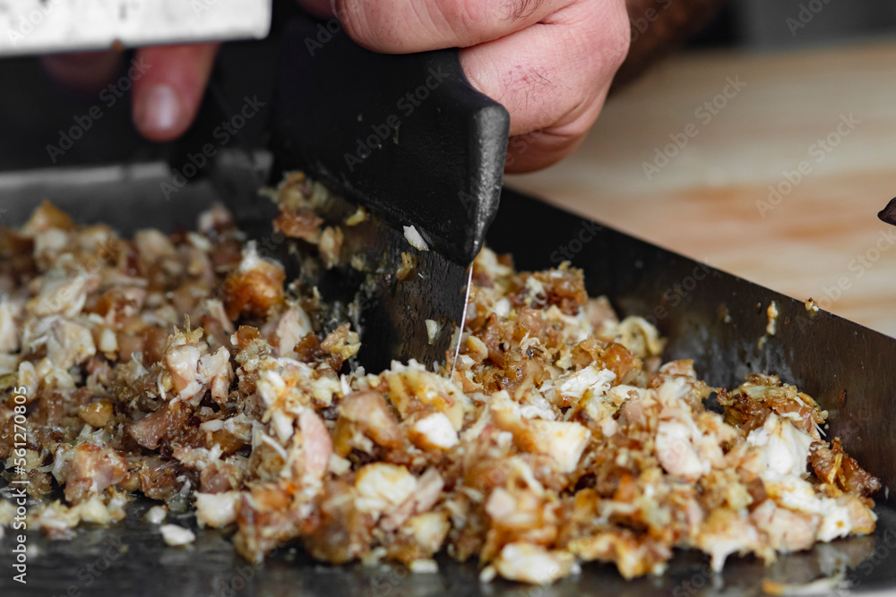 Man cutting prepared meat for Shawarma Man cutting prepared meat for Shawarma
