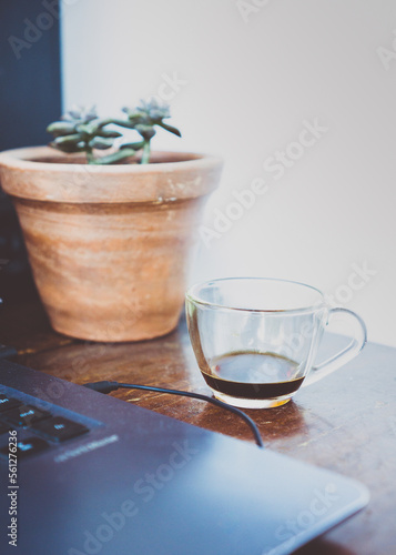 Close-up of a cup of coffee near a notebook on the table. 
