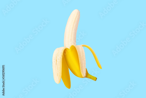 Fresh raw yellow banana peeled in flight. On a blue background.