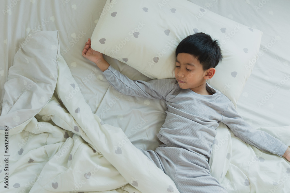Top View of Asian boy having good dreams while Sleeping Cozily Top View of Asian boy having good dreams while Sleeping Cozily