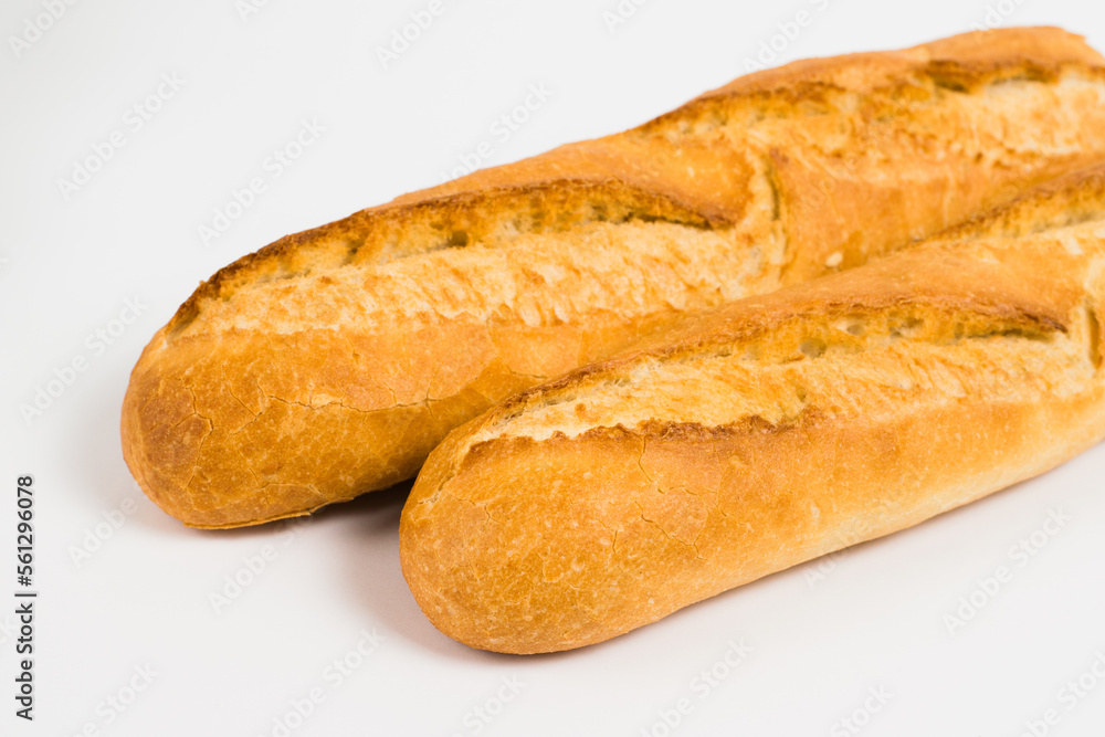 French baguettes on a white background with copy space. Delicious appetizing crust of a bun close-up