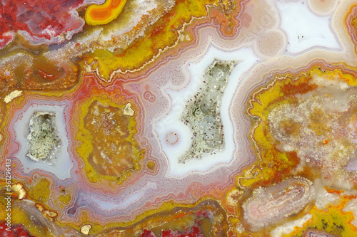 A cross section of the agate stone with quartz geode. Multicolored silica bands colored with metal oxides are visible. Macro photography of the surface of the cut. Origin: Atlas mountains, Morocco. photo