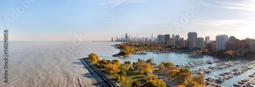 Aerial panorama overlooking Belmont harbor peninsula and the Lakeview neighborhood with the Chicago skyline in the distance.