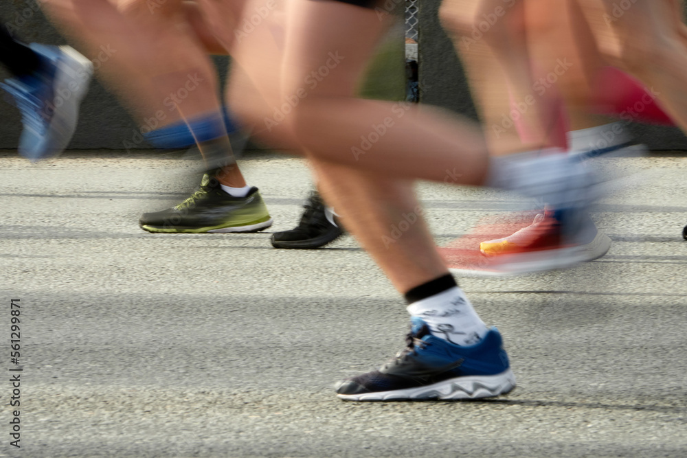 Fototapeta premium Marathon running race, people feet on city road.