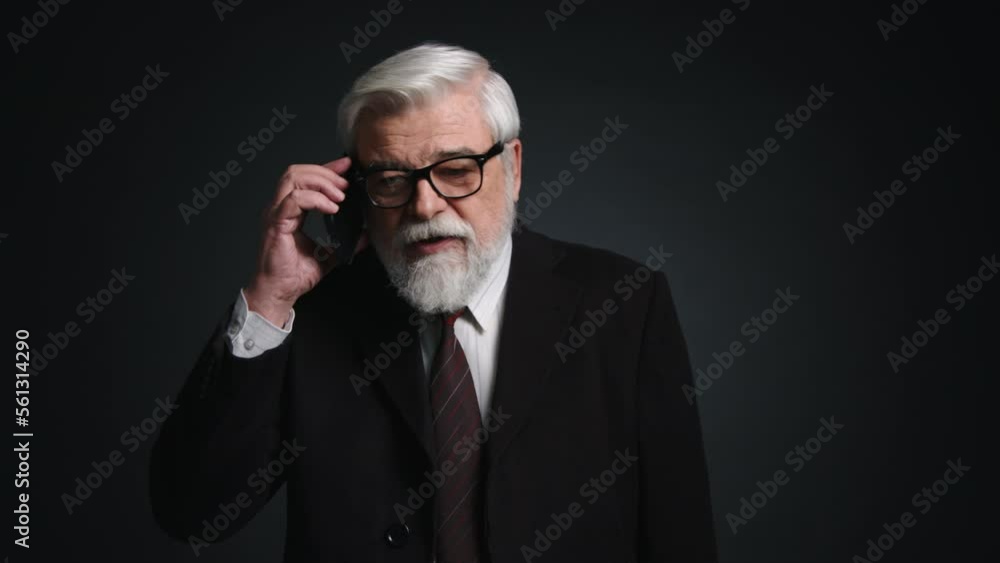 Portrait of caucasian adult man talking on the telephone. Close-up view of a senior businessman using his smartphone indoors. High quality 4k footage Portrait of caucasian adult man talking on the telephone. Close-up view of a senior businessman using his smartphone indoors. High quality 4k footage