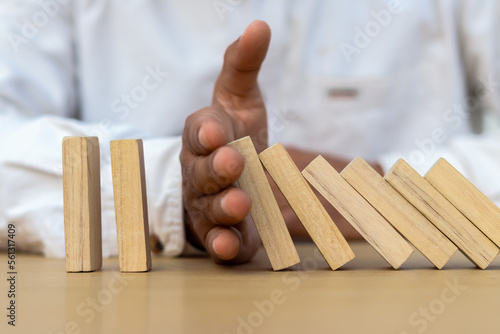 Papier peint Risk and strategy in business is hand stopping the fall of wooden block