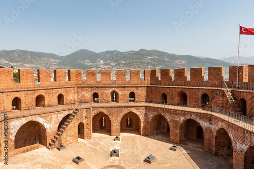 фотографія The imposing battlements of the Seljuk era Red Tower or Kizi Kule overlooking Alanya harbor with the Taurus Mountains in the background