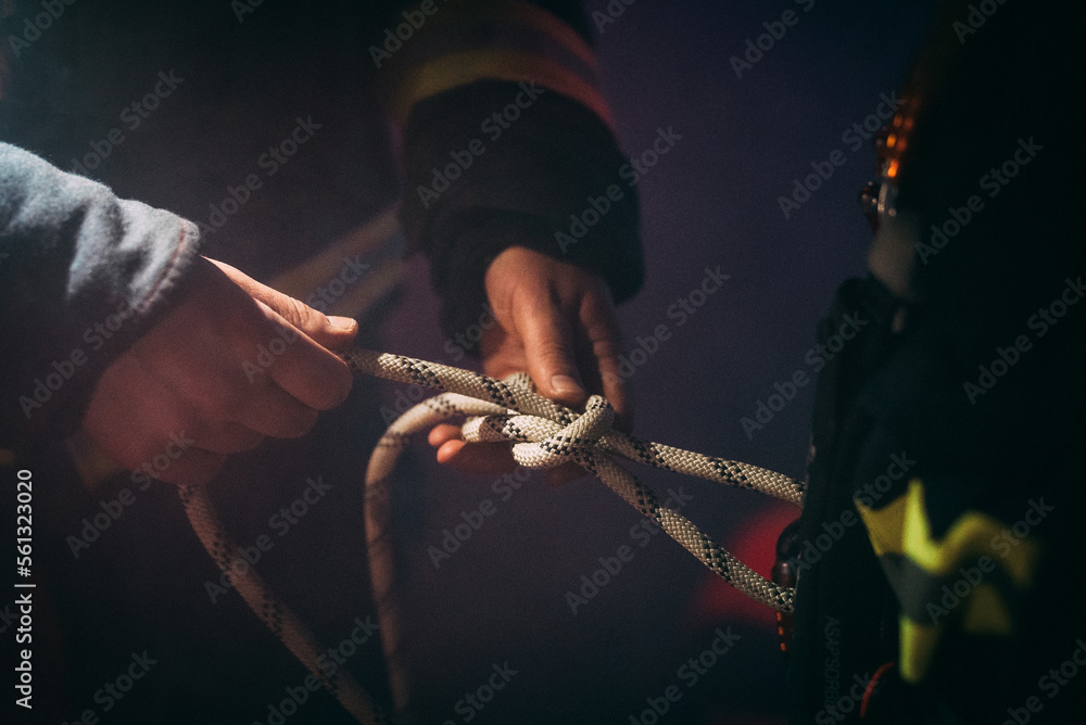 Firefighter tightening a knot. Stock Photo Adobe Stock