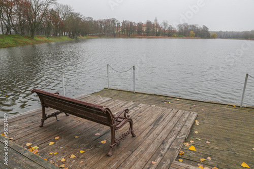 A rest bench stands on the river pier.