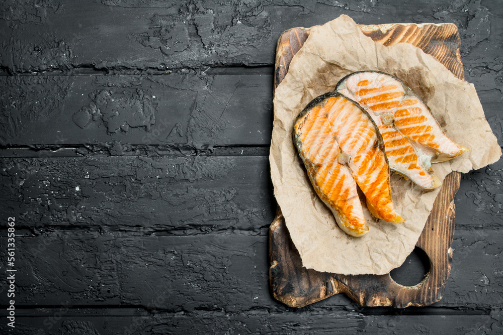 Grilled salmon steaks on old paper. Grilled salmon steaks on old paper.