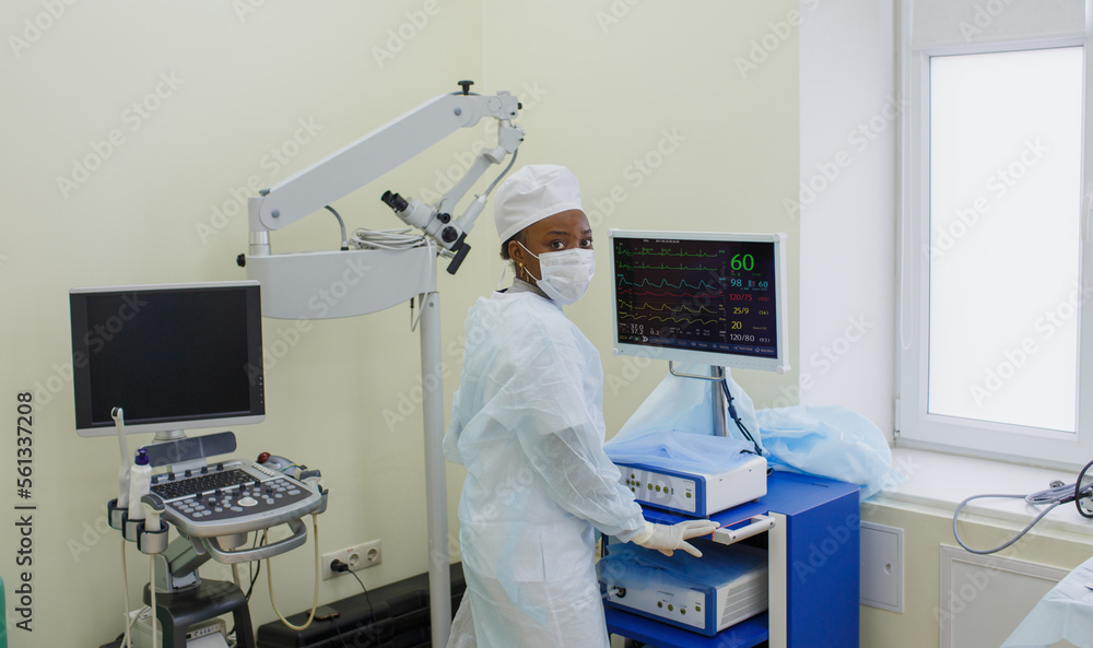 Naklejka premium an African-American nurse near the screen of artificial ventilation equipment. Hospital, surgical operating room