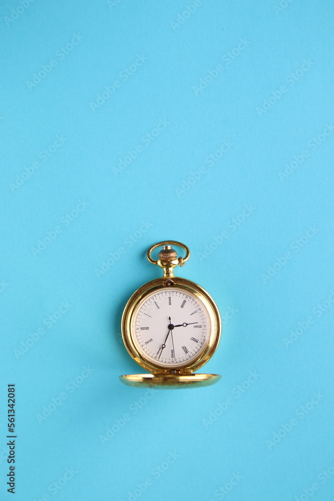 Golden pocket watch on a blue background. Golden pocket watch on a blue background.